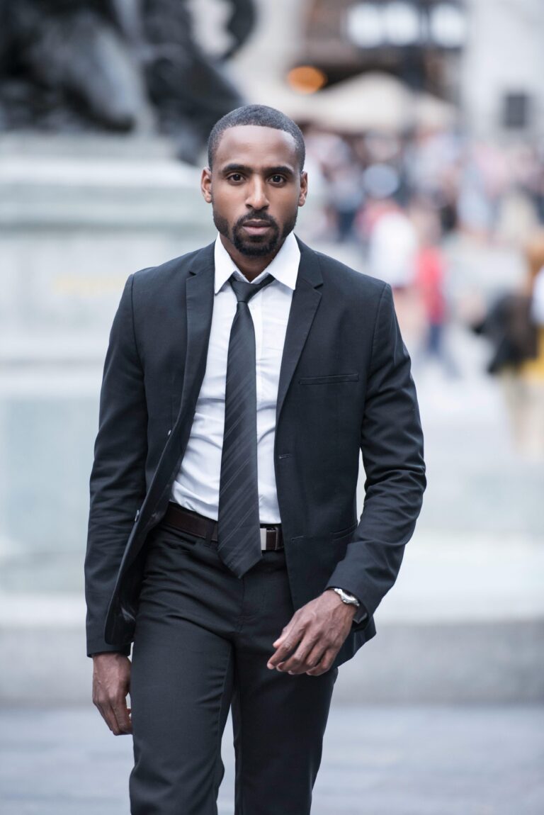 Confident businessman in a designer suit walking in an urban setting.